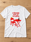 Camiseta A felicidade mora no simples — branca, na bancada de madeira